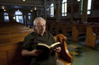Foto: Senior man reading a bible in church Senior man reading a bible in church