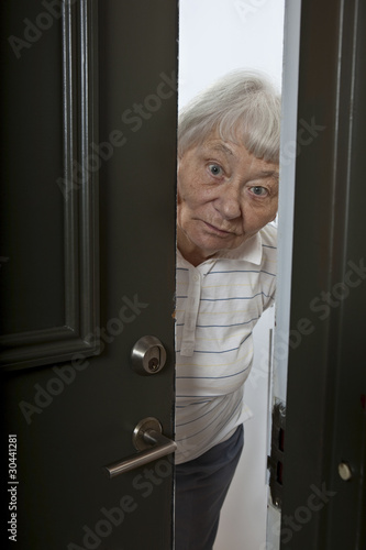 Photo: Senior woman opening front door Senior woman opening front door