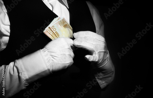 Photo: Corruption -butler putting money in his pocket Corruption -butler putting money in his pocket