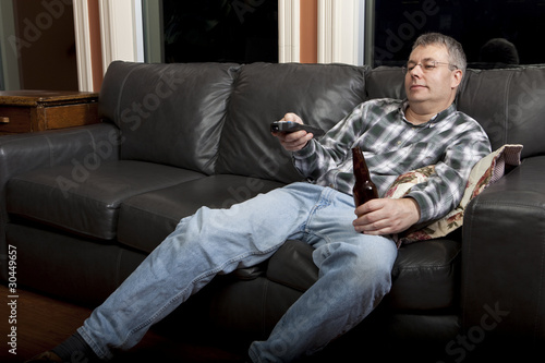 Photo: Couch potato watching TV and drinking beer Couch potato watching TV and drinking beer