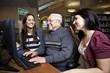 Foto: Volunteers teaching a senior how to use a computer Volunteers teaching a senior how to use a computer