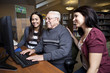 Photo: Volunteers teaching a senior how to use a computer Volunteers teaching a senior how to use a computer