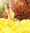 Young beautiful girl in a yellow dress in the woods