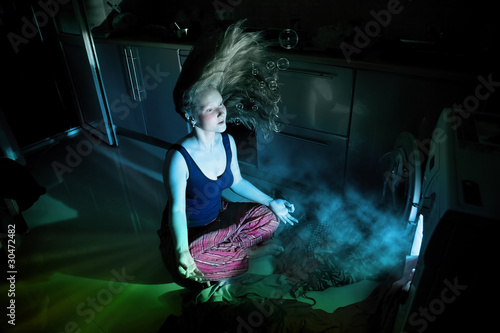 Photo: Woman near by washing machine underwater Woman near by washing machine underwater