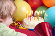 child blowing candles out