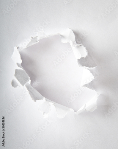 Photo: Hole in the paper with torn sides Hole in the paper with torn sides