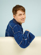 Happy smiling man sitting on couch in dressing gown