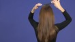 Video: woman brushing her hair on a blue background woman brushing her hair on a blue background