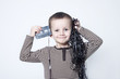 Portrait of cute boy playing with old tapes
