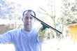 Mann beim Fenster putzen