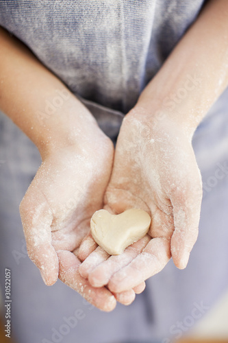 Foto: Close up of girl holding heart-shape dough Close up of girl holding heart-shape dough