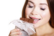 Pretty young woman eating chocolate