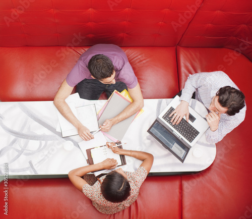 Photo: Business people sitting in booth having a meeting Business people sitting in booth having a meeting