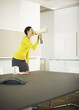 Businesswoman shouting in bullhorn in conference room