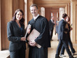 Smiling judge and lawyer in corridor