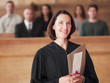 Smiling judge holding file in courtroom