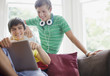 Smiling teenage boys using digital tablet together