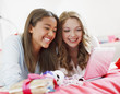 Smiling teenage girls using laptop together
