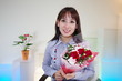 プレゼントの花束を持った笑顔の女性
