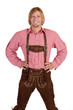 Glücklicher Mann mit Oktoberfest Lederhose hält Hände auf Hüfte