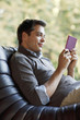 Man reclining in chair reading electronic book