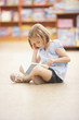 Girl sitting on floor reading book