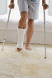 Man with broken leg walking on crutches