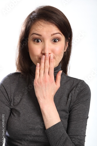 Photo: Oops hand signal by pretty young woman with hand over mouth Oops hand signal by pretty young woman with hand over mouth