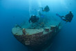 Photo: Silhouettes of scuba divers exploring the bow of a shipwreck. Silhouettes of scuba divers exploring the bow of a shipwreck.