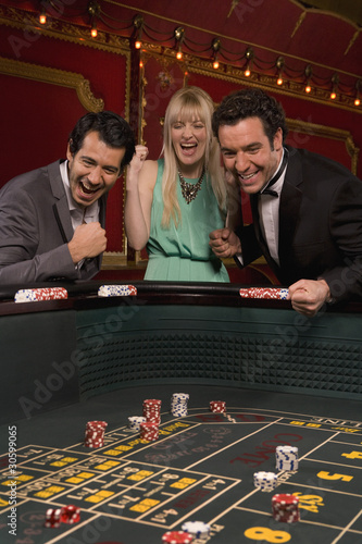 Photo: Excited friends winning at craps table Excited friends winning at craps table