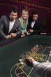 People watching man throwing dice at craps table