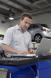 Mechanic working on laptop on auto repair shop