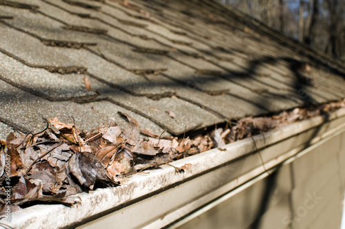 Photo: house roof gutter filled with leaves autumn house roof gutter filled with leaves autumn