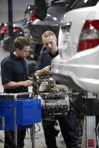 Photo: Mechanics working on engine in auto repair shop Mechanics working on engine in auto repair shop