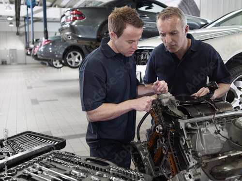 Photo: Mechanics working on engine in auto repair shop Mechanics working on engine in auto repair shop