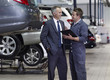 Businessman talking to mechanic in auto repair shop