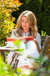 Frau beim Buch lesen im Garten