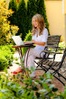 Frau mit Laptop im Garten