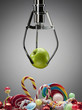 Hook with green apple above variety of sweet candies