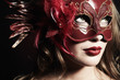 Photo: Beautiful young woman in a red mysterious venetian mask Beautiful young woman in a red mysterious venetian mask
