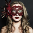 Photo: Beautiful young woman in a red mysterious venetian mask Beautiful young woman in a red mysterious venetian mask