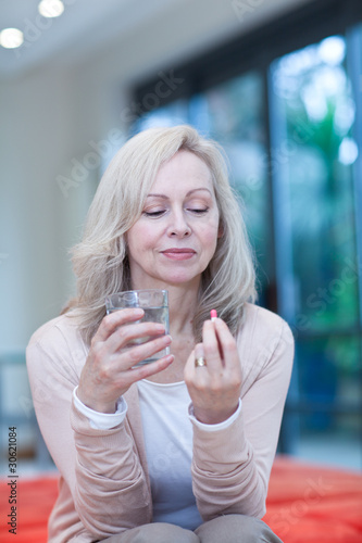 Photo: Mature woman taking medicine Mature woman taking medicine