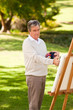 Elderly man painting in the park Elderly man painting in the park