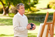 Elderly man painting in the park Elderly man painting in the park