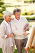 Retired couple painting in the park Retired couple painting in the park