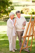 Retired couple painting in the park Retired couple painting in the park
