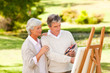 Retired couple painting in the park Retired couple painting in the park