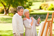 Retired couple painting in the park Retired couple painting in the park