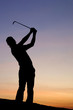 A male golfer enjoys an early round during sunrise. A male golfer enjoys an early round during sunrise.
