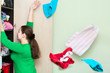 Young caucasian woman throwing clothes from wardrobe back